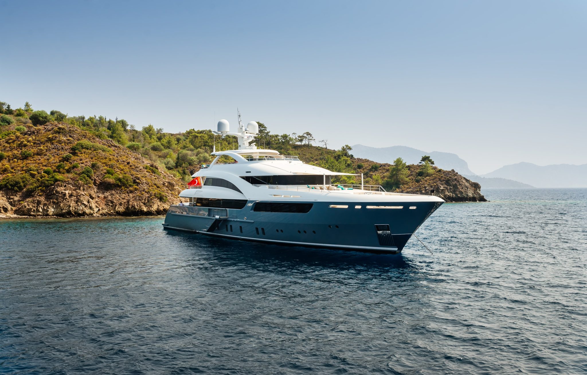 luxury big yacht stay in the sea around the island on a background of the sky