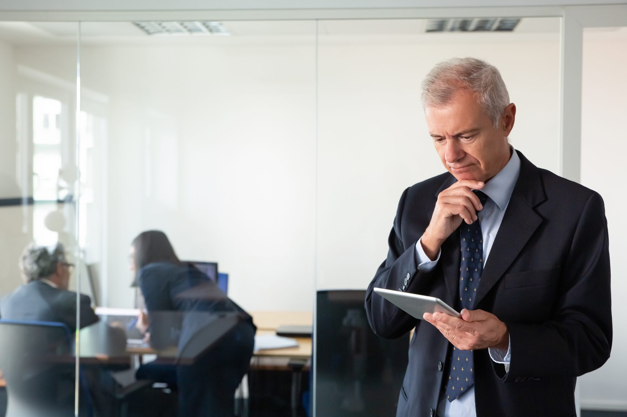 focused pensive businessman staring at tablet screen